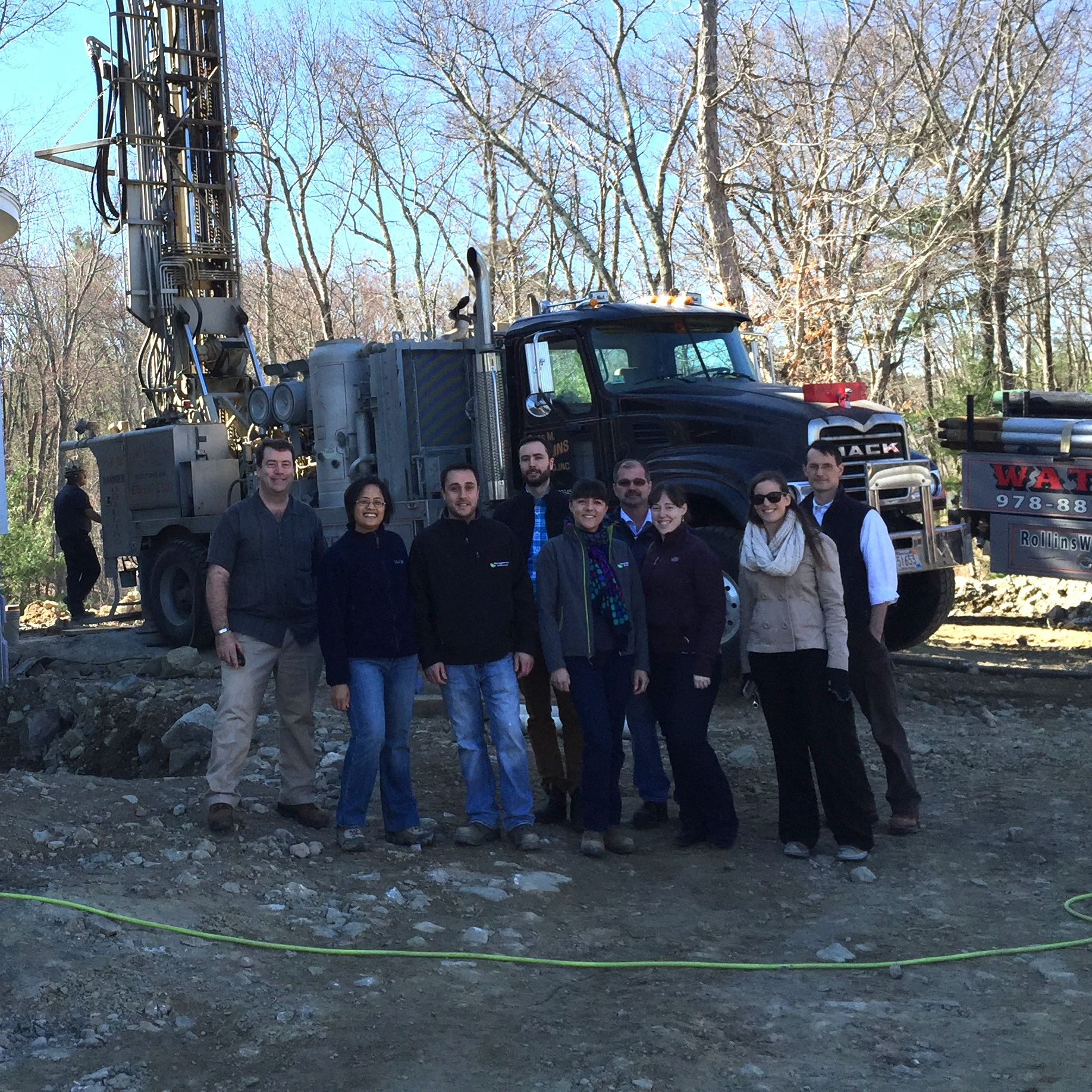 photo of a group of people outdoors at a construction site in front of a large truck