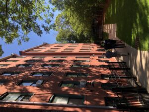 photo of people walking outdoors next to a large brick building