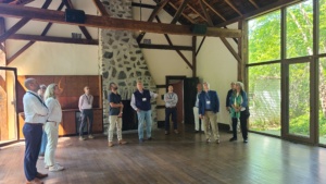 A group of 11 people in a refurbished barn looking at the ceiling